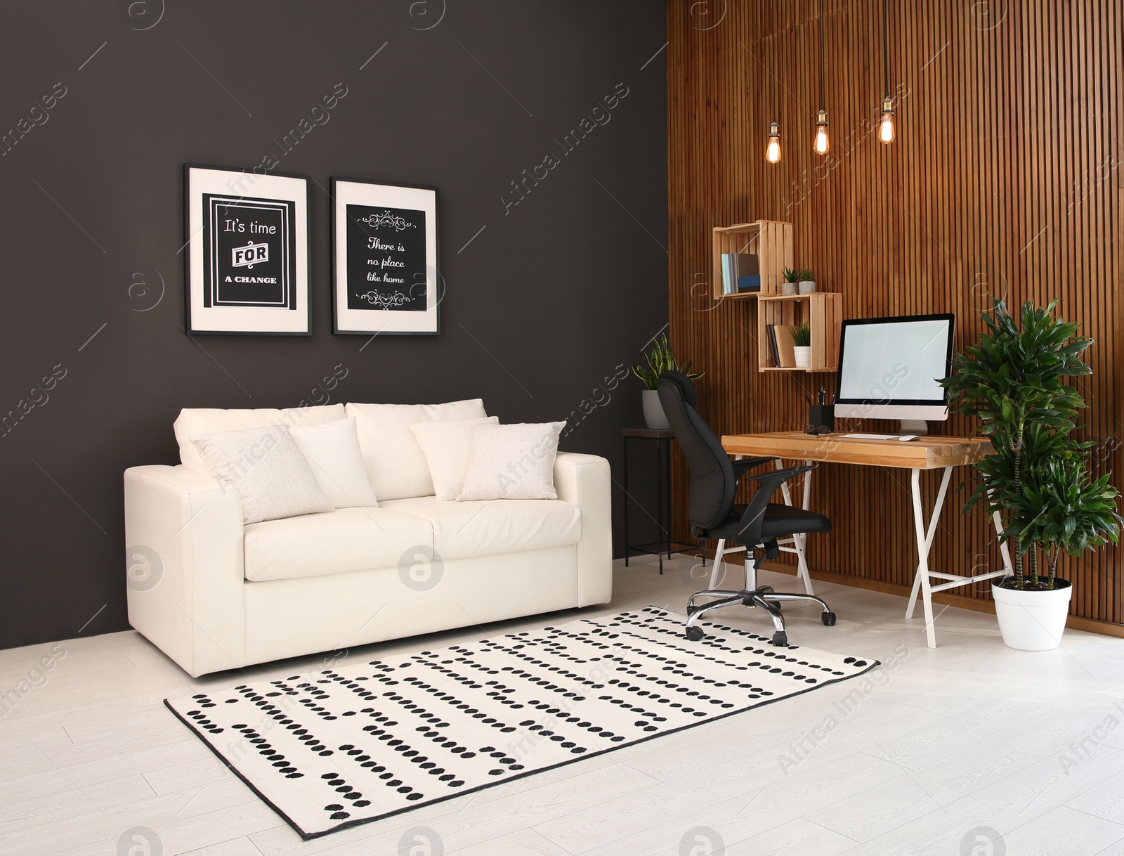 Photo of Comfortable workplace with computer near wooden wall in stylish room interior. Home office design