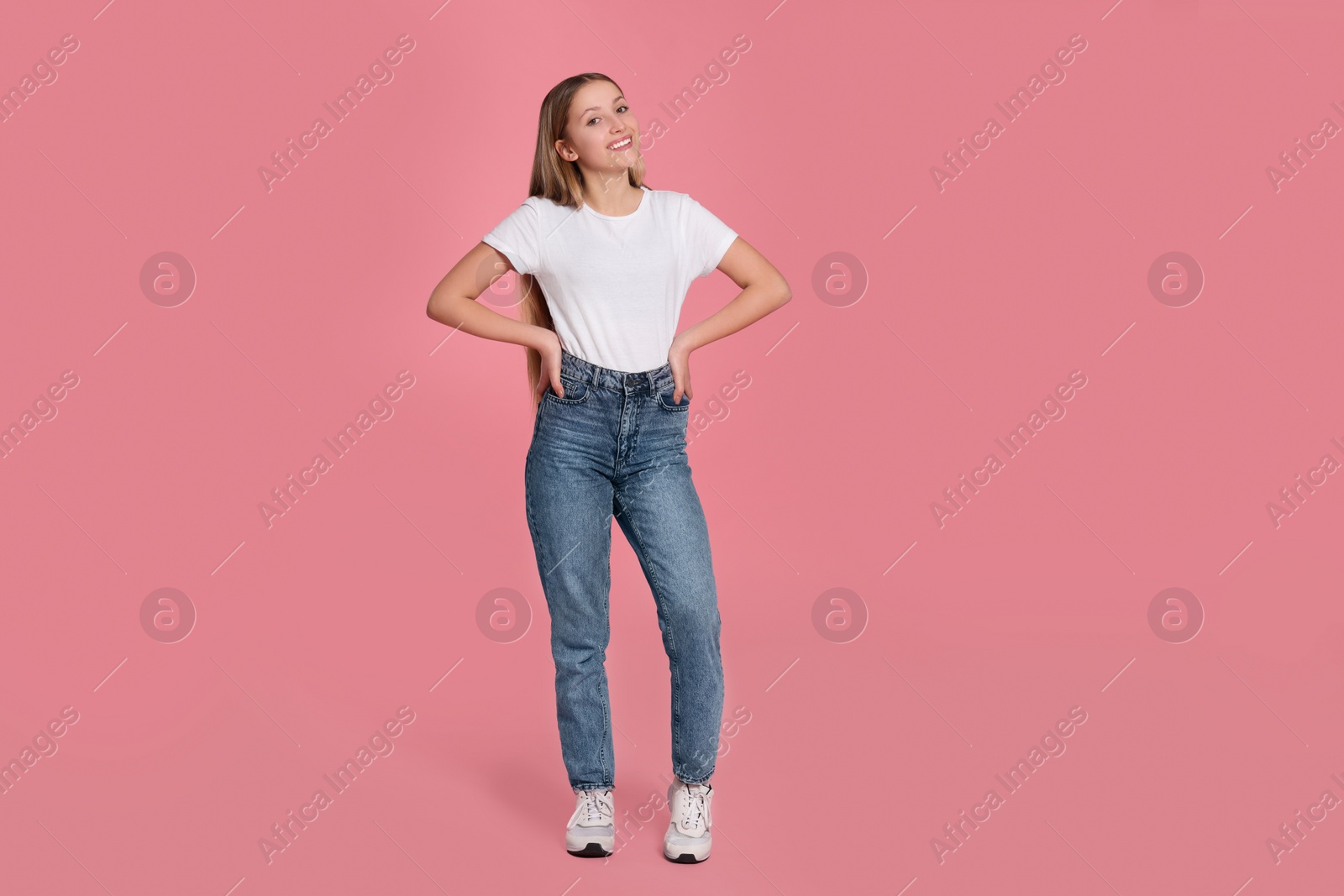 Photo of Full length portrait of beautiful teenage girl in casual clothes on pink background