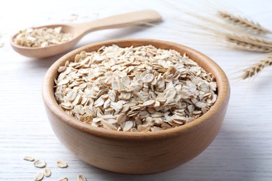 Photo of Oatmeal, bowl and spoon on white wooden table