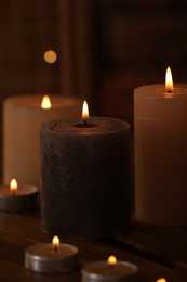 Spa composition with burning candles on wooden table in wellness center, closeup