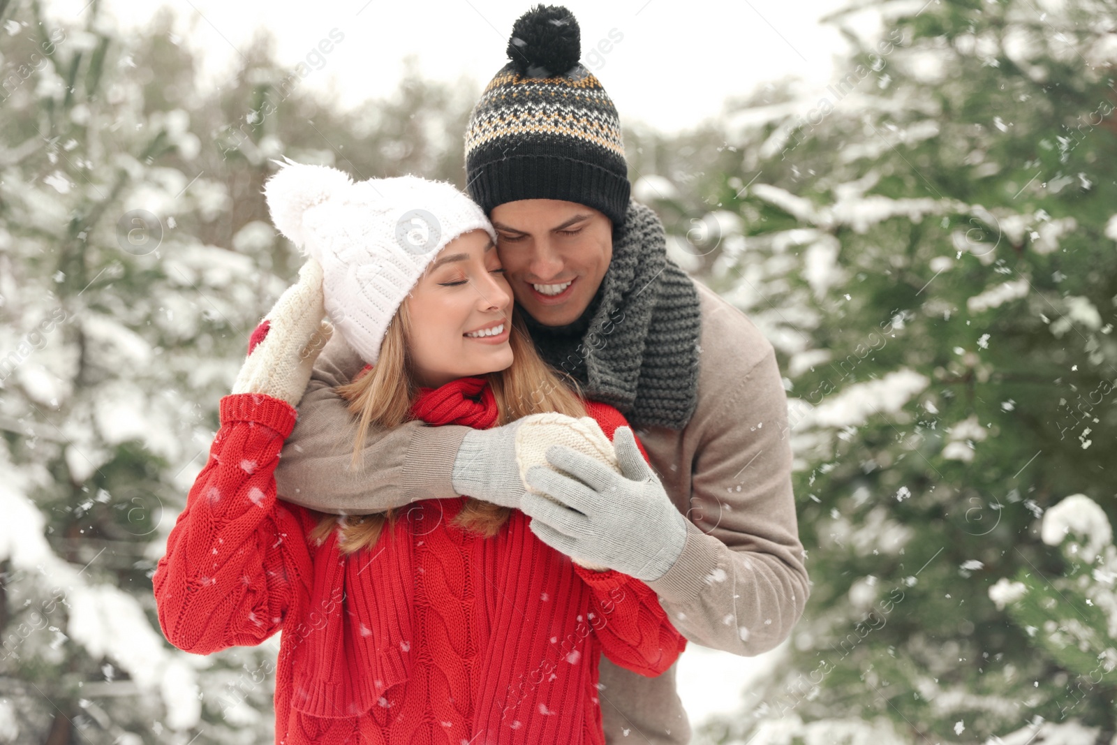 Photo of Beautiful happy couple in snowy forest on winter day