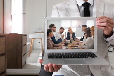 Image of Businessman attending online video conference via modern laptop indoors, closeup