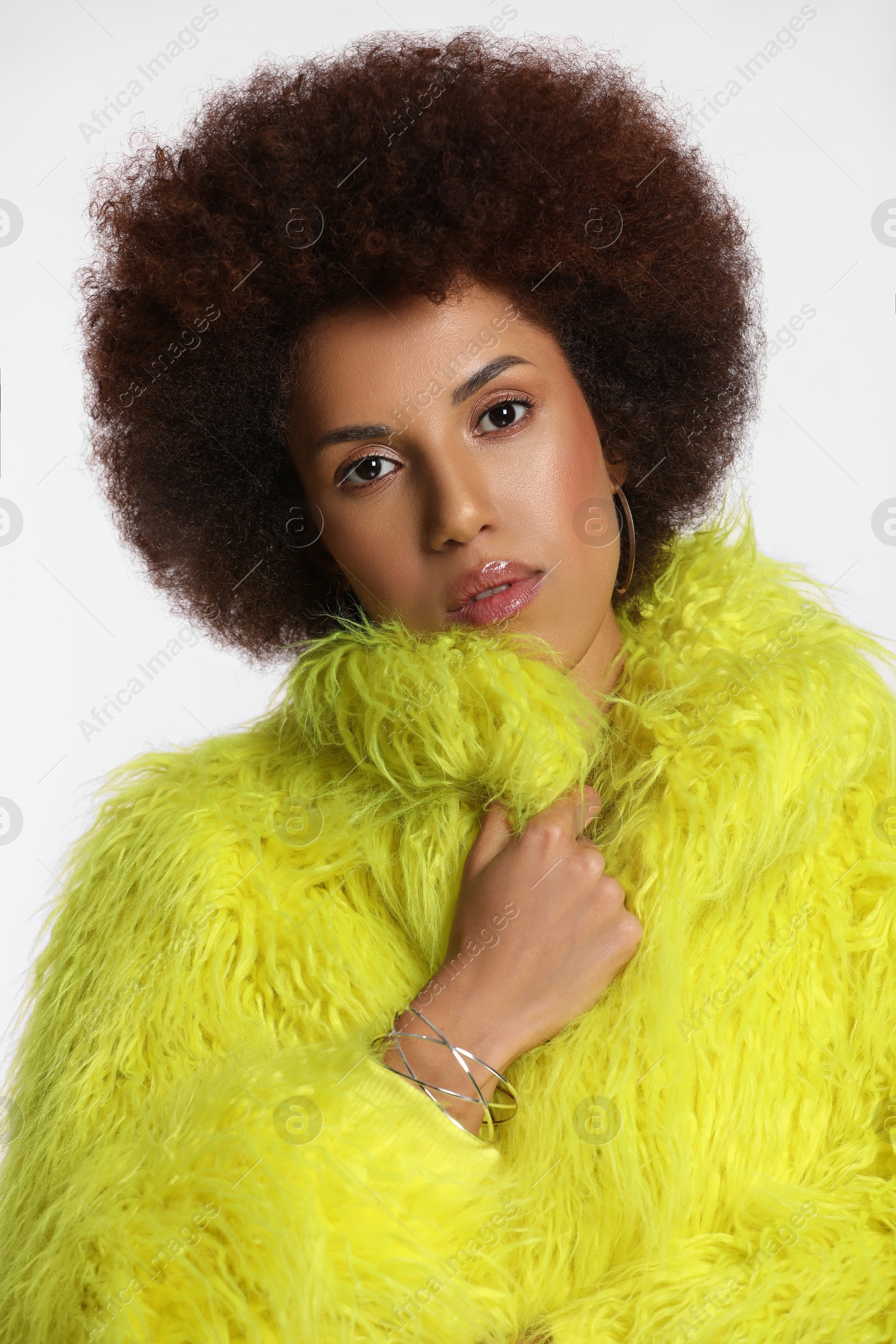 Photo of Portrait of beautiful young woman in stylish yellow fur coat on white background