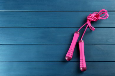 Photo of Skipping rope on blue wooden table, top view. Space for text