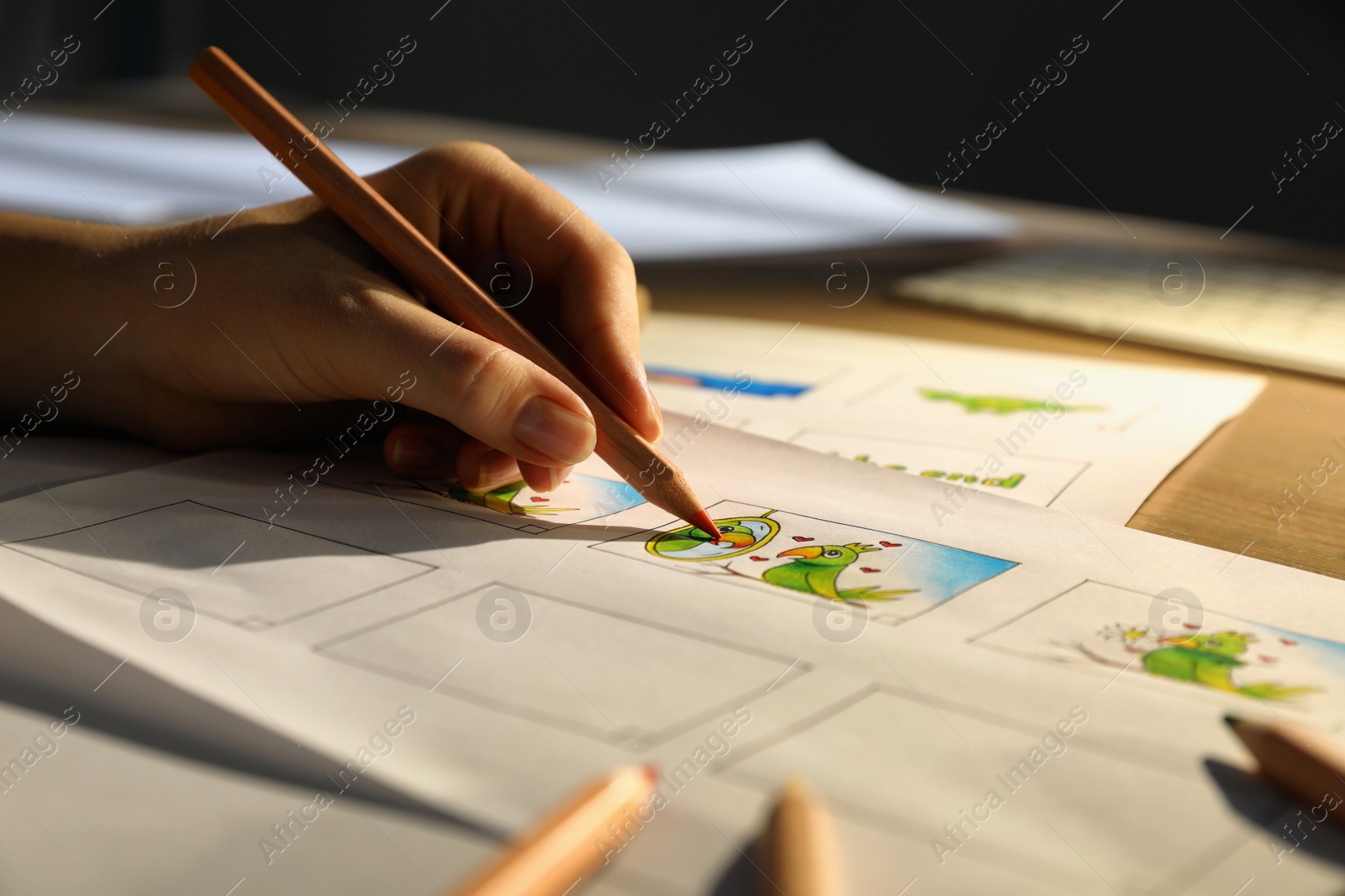 Photo of Woman drawing cartoon sketches at workplace, closeup. Pre-production process