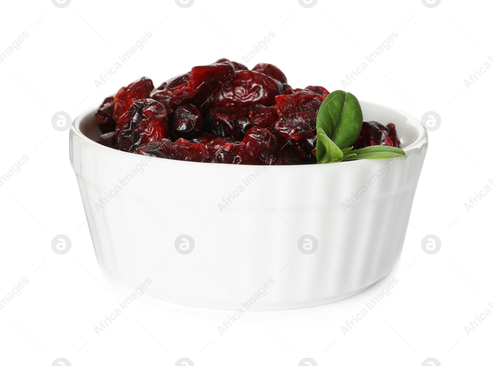 Photo of Dried cranberries and leaves in bowl isolated on white