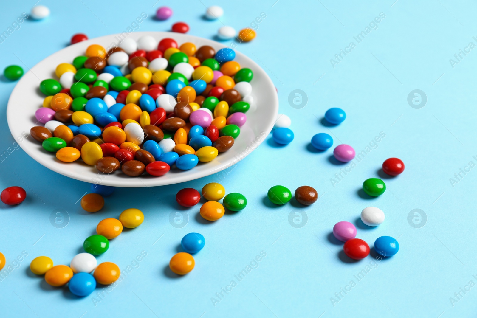 Photo of Delicious glazed candies on light blue background