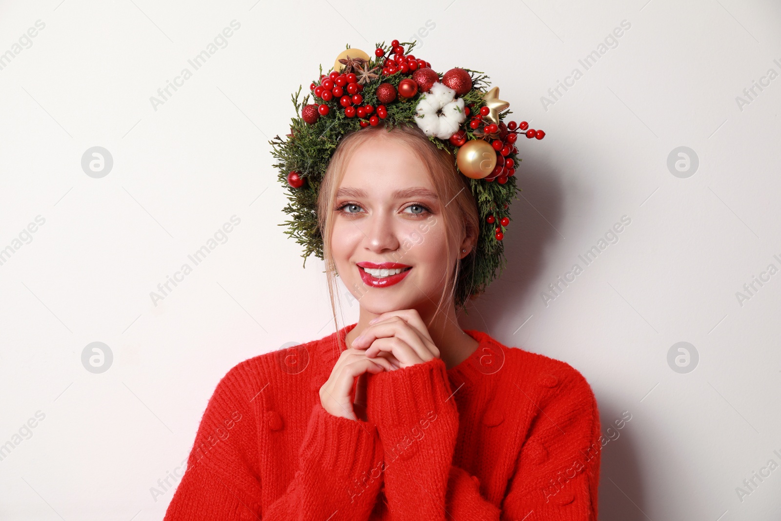 Photo of Beautiful young woman wearing Christmas wreath on white background