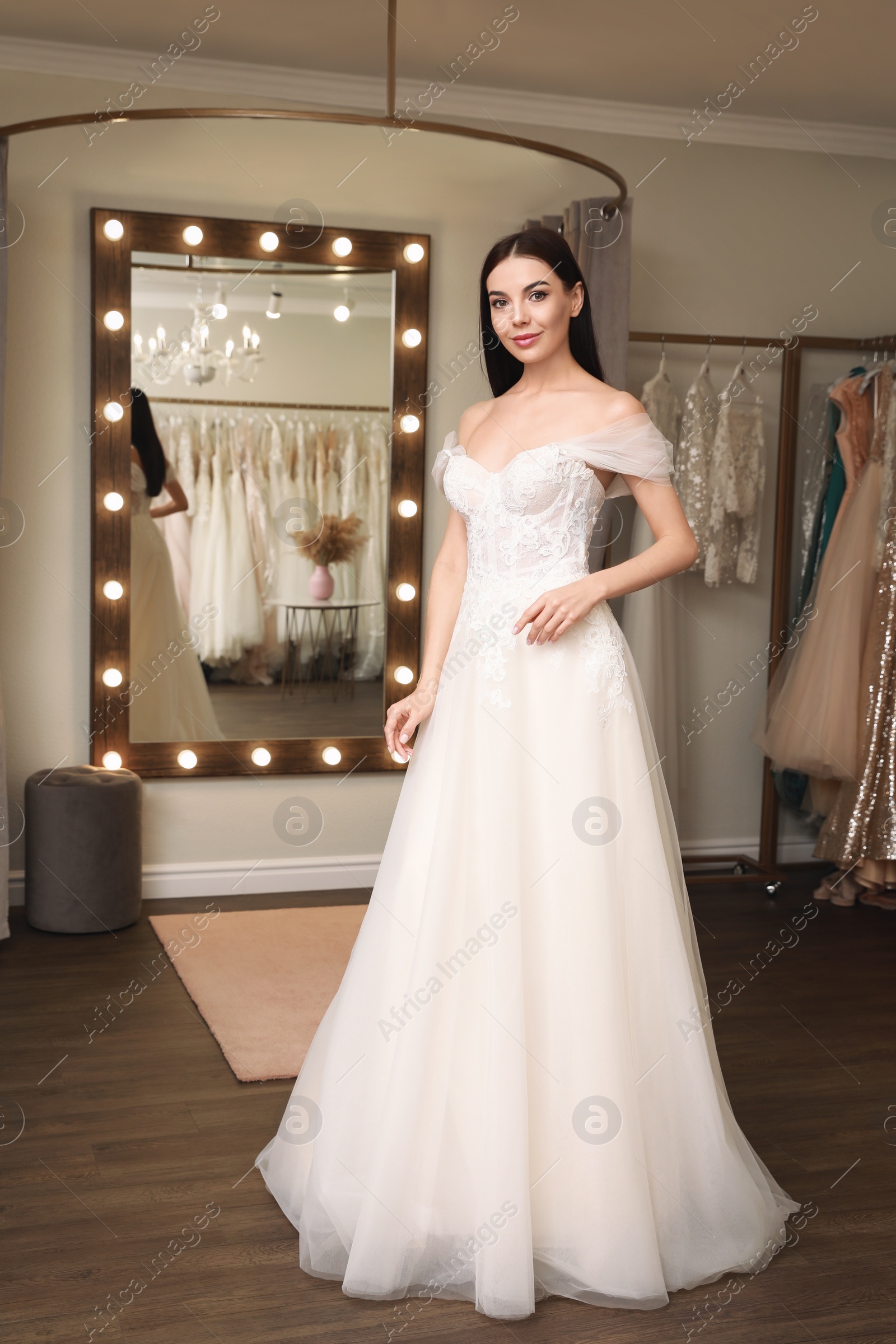 Photo of Woman trying on wedding dress in boutique