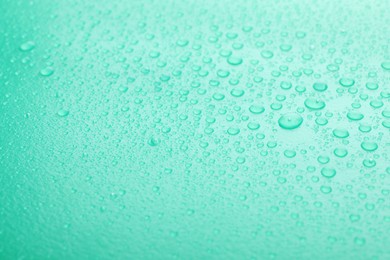 Water drops on turquoise background, closeup view