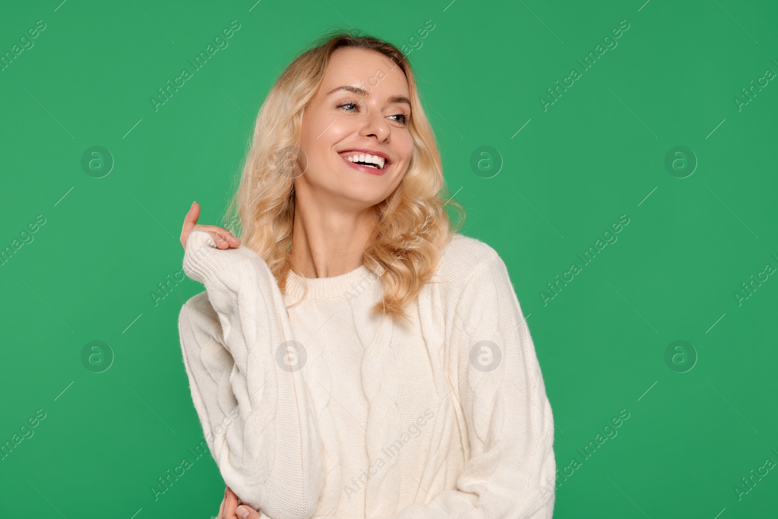 Photo of Happy woman in stylish warm sweater on green background