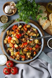 Delicious ratatouille and ingredients on grey table, flat lay