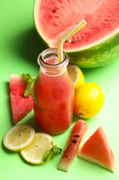 Photo of Tasty watermelon drink and fresh fruits on green background, closeup