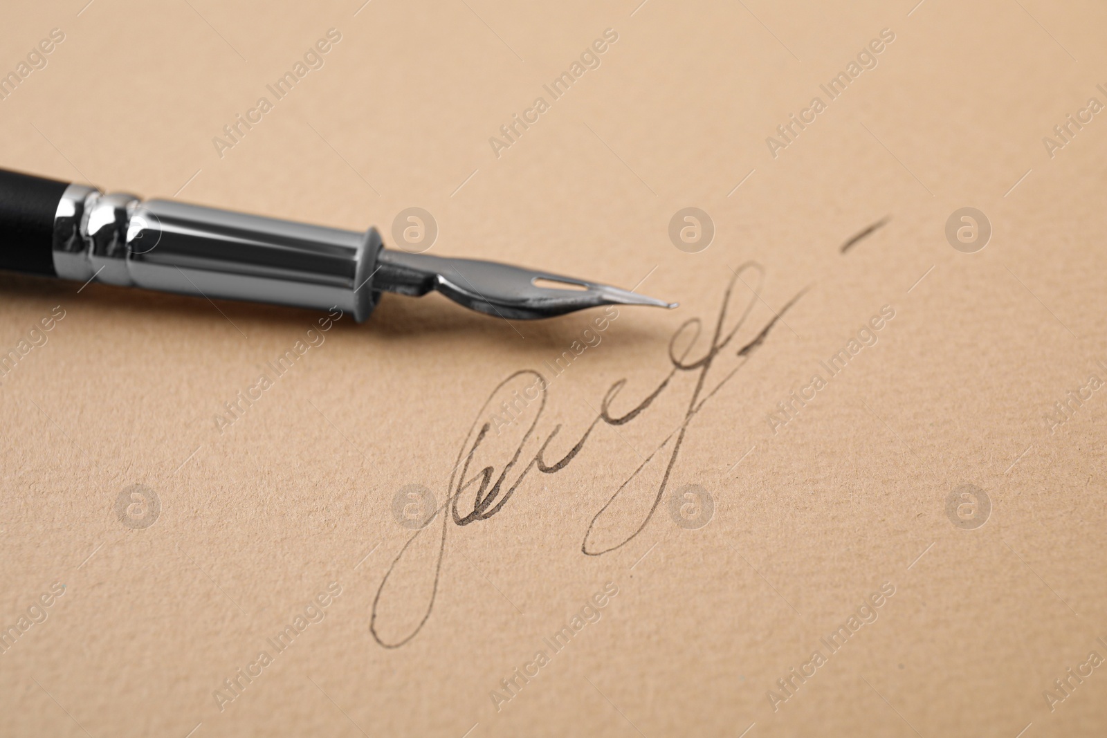 Photo of Signature and fountain pen on sheet of paper, closeup
