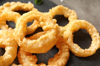 Photo of Homemade crunchy fried onion rings on table, closeup