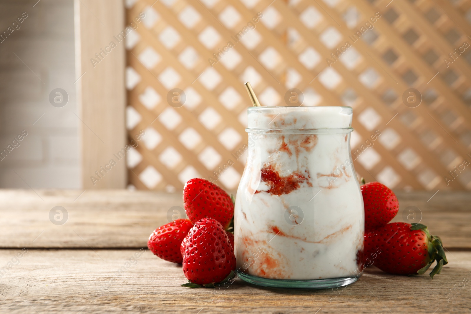 Photo of Tasty yoghurt with jam and strawberries on wooden table, closeup. Space for text