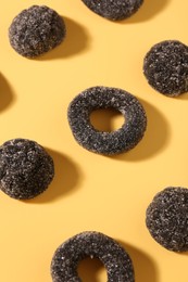 Photo of Tasty liquorice candies on yellow background, above view