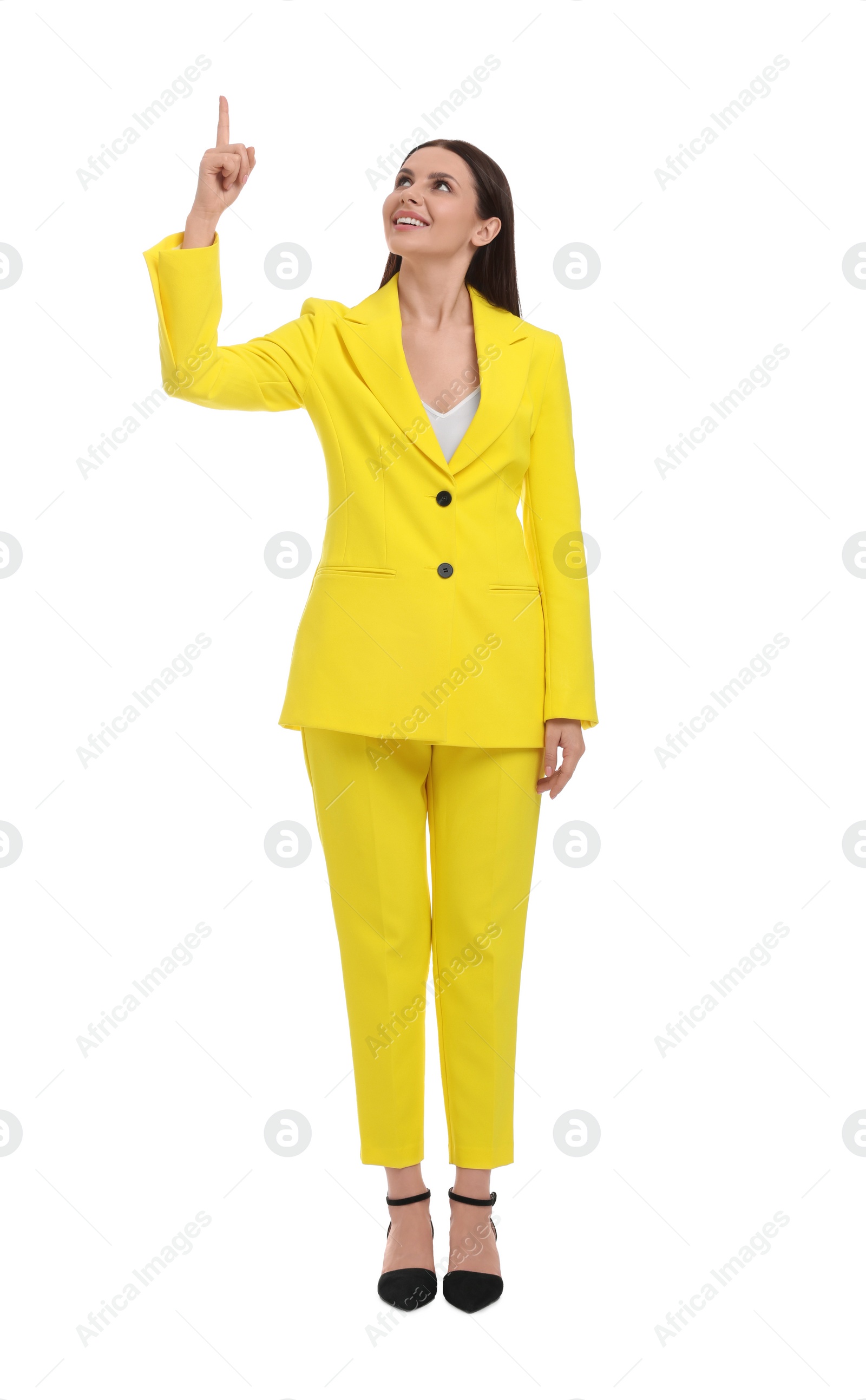 Photo of Beautiful businesswoman in yellow suit pointing at something on white background