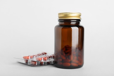 Photo of Bottle and blisters with pills on light background. Anemia treatment