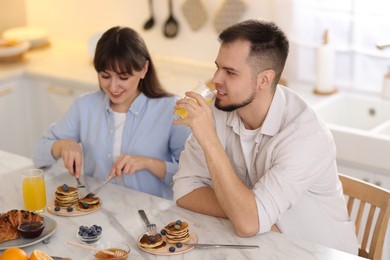 Happy couple having tasty breakfast at home