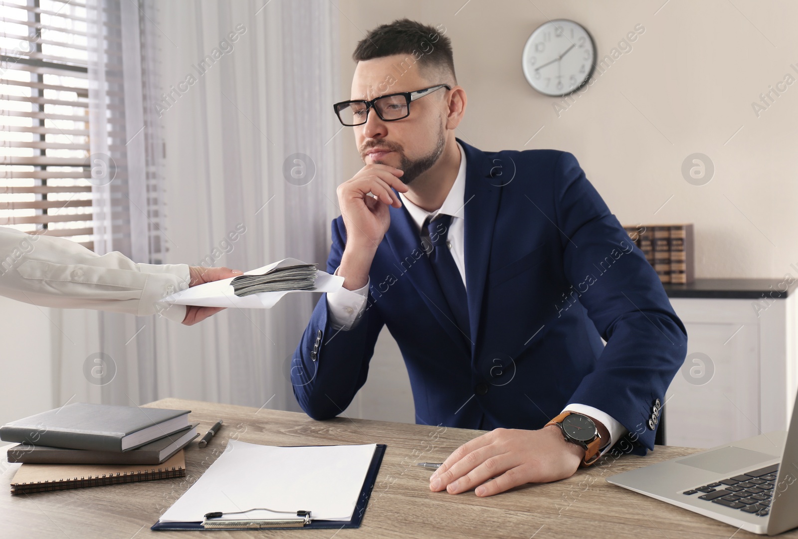 Photo of Woman offering bribe to man at table in office