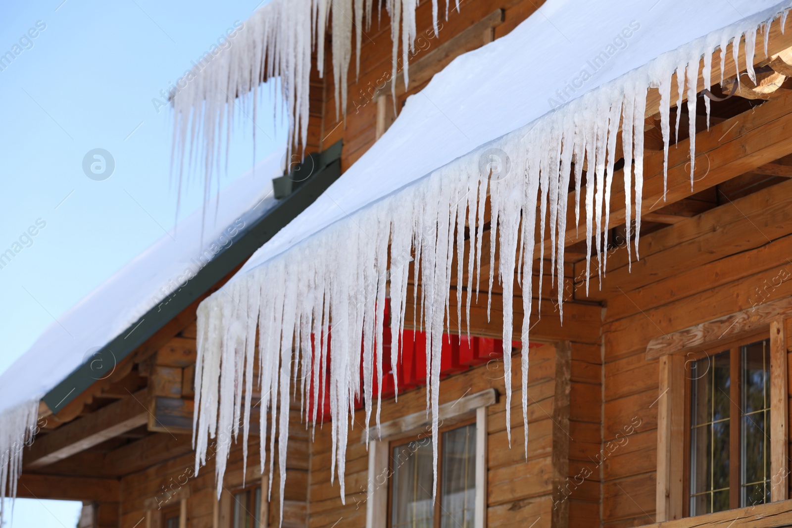 Photo of House with icicles on roof. Winter season