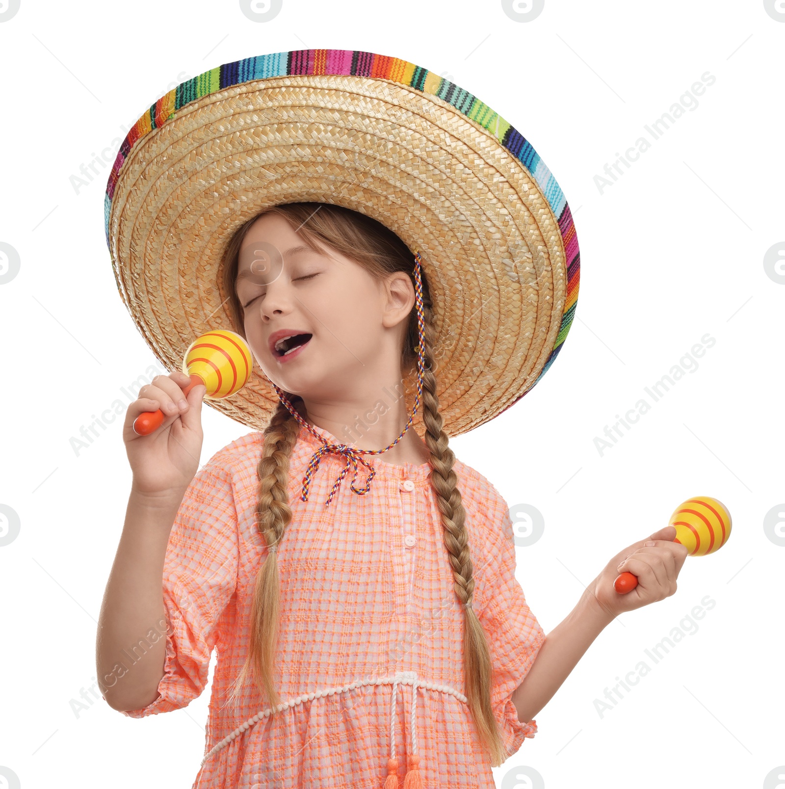 Photo of Cute girl in Mexican sombrero hat singing with maracas on white background