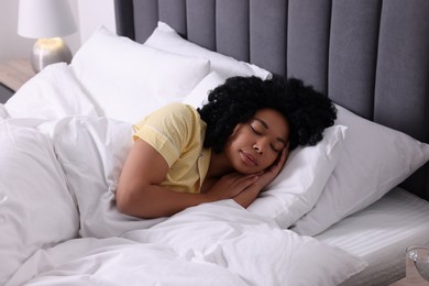 Photo of Beautiful young woman sleeping in soft bed at home