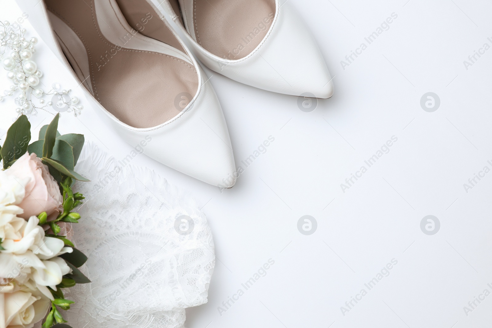 Photo of Pair of wedding high heel shoes on white background, top view