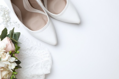 Photo of Pair of wedding high heel shoes on white background, top view