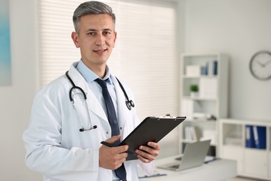 Photo of Doctor with stethoscope and clipboard in clinic, space for text