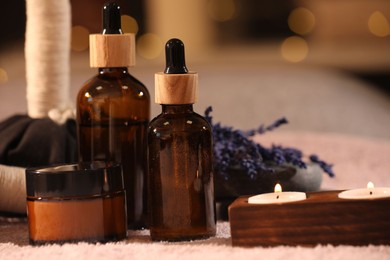Photo of Composition with spa products and burning candles on soft light surface, closeup