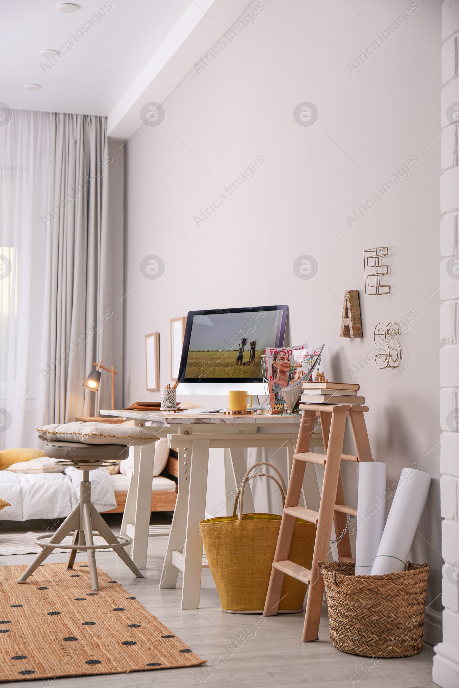 Photo of Comfortable workplace with modern computer near light wall. Interior design