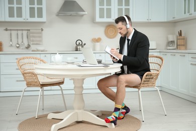 Photo of Businessman in underwear pretending to wear formal clothes during video call at home