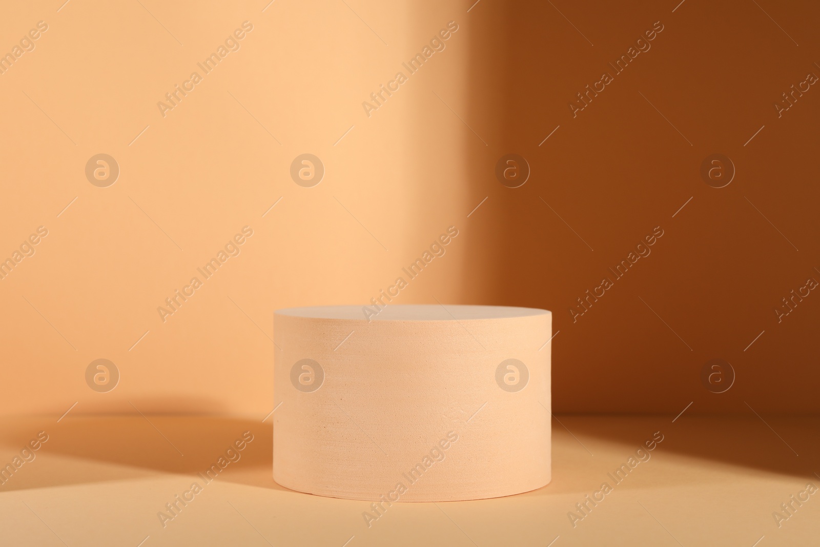 Photo of Presentation of product. Podium and shadows on orange background. Space for text