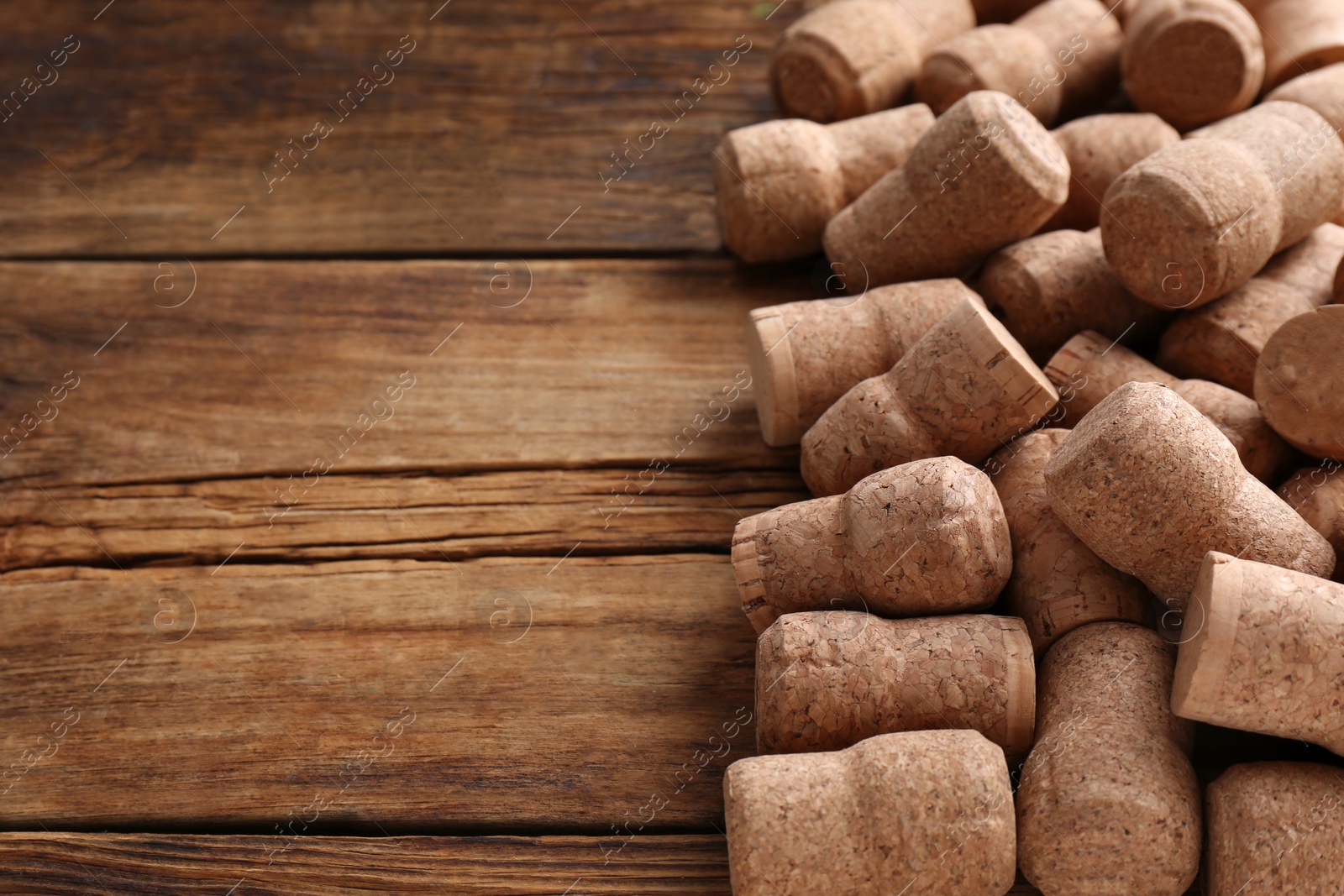 Photo of Sparkling wine bottle corks on wooden table. Space for text