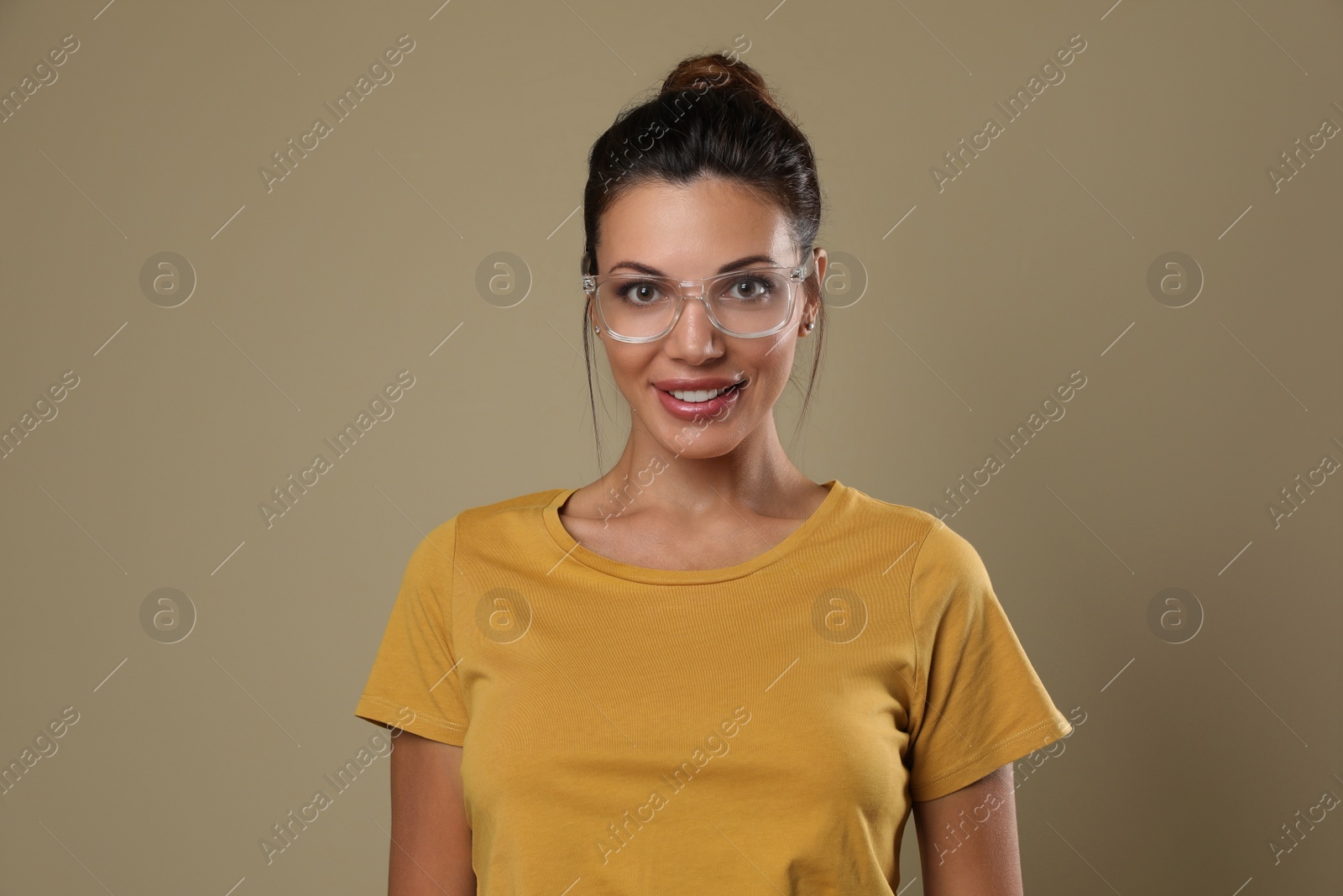 Photo of Beautiful woman in eyeglasses on beige background