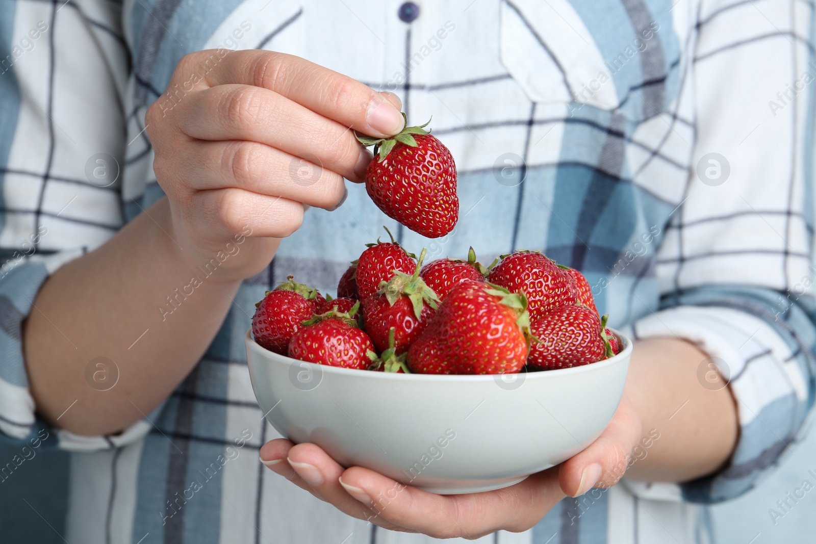 Photo of Woman holding bowl with tasty fresh strawberries, closeup