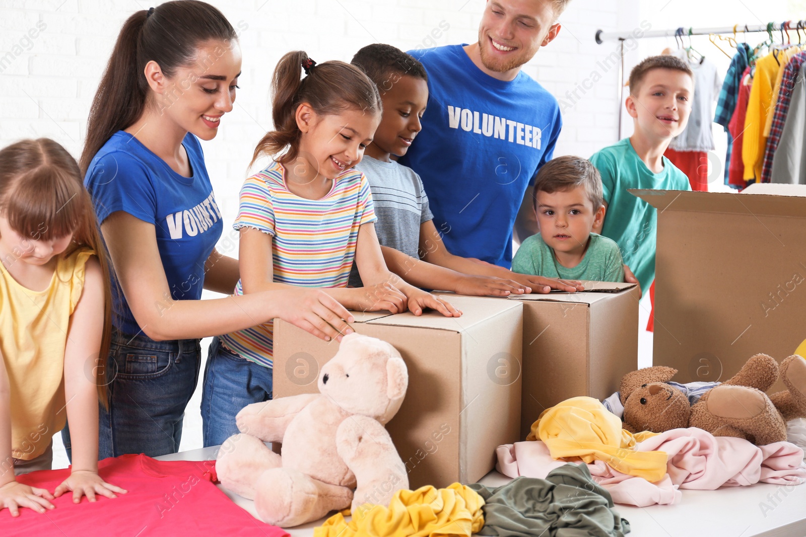 Photo of Volunteers with children sorting donation goods indoors