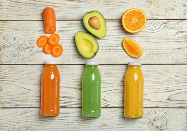 Photo of Flat lay composition with tasty juices and ingredients on wooden background