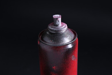 Photo of One spray paint can on dark background, closeup