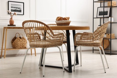 Dining room interior with wooden table and wicker chairs