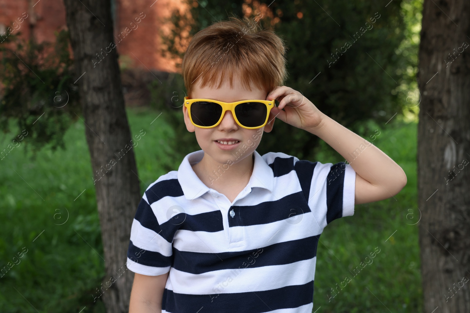 Photo of Cute little boy with sunglasses in park