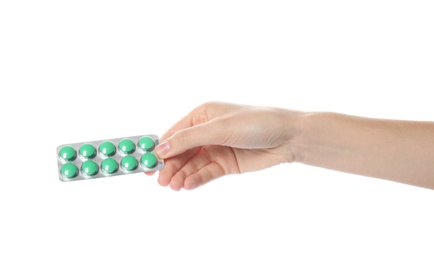 Woman holding pills in blister pack on white background, closeup