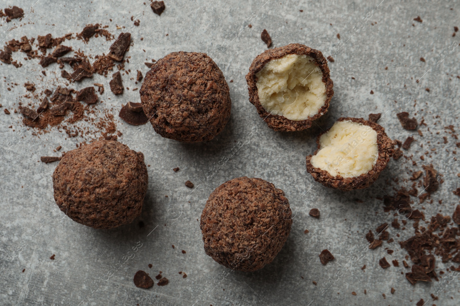 Photo of Many delicious chocolate truffles on grey table, flat lay