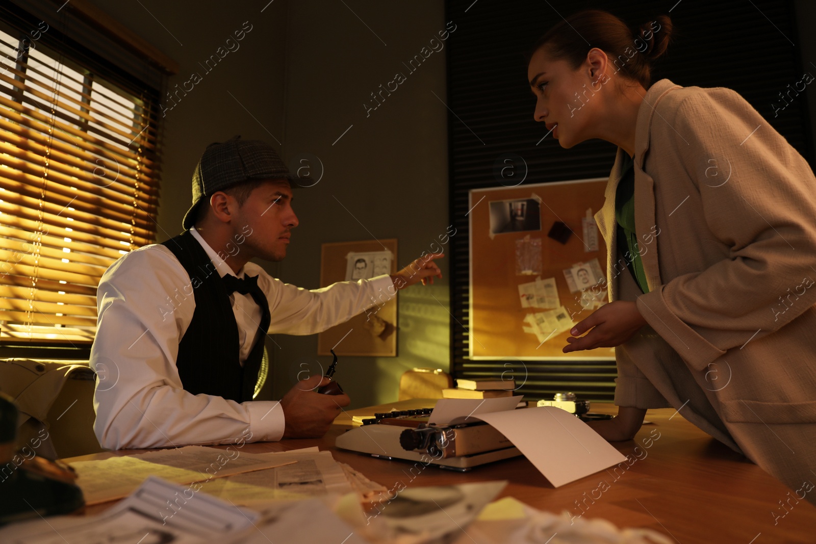 Photo of Old fashioned detective working with client in office