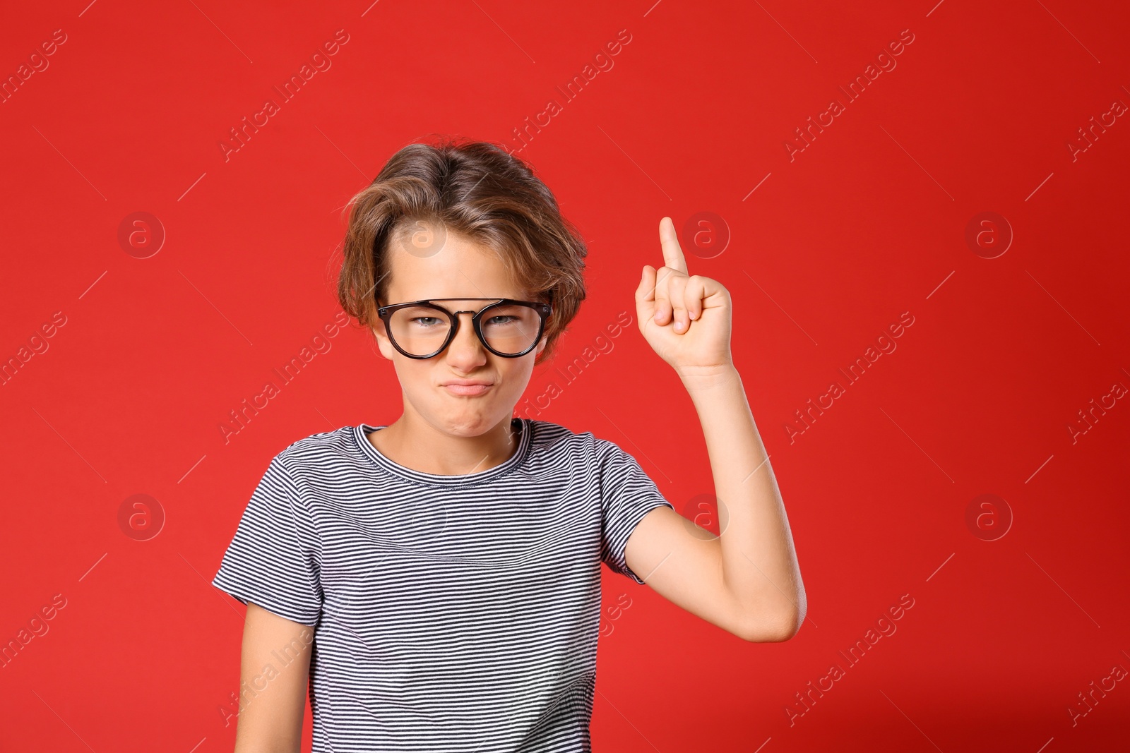 Photo of Cute little boy in casual outfit on red background