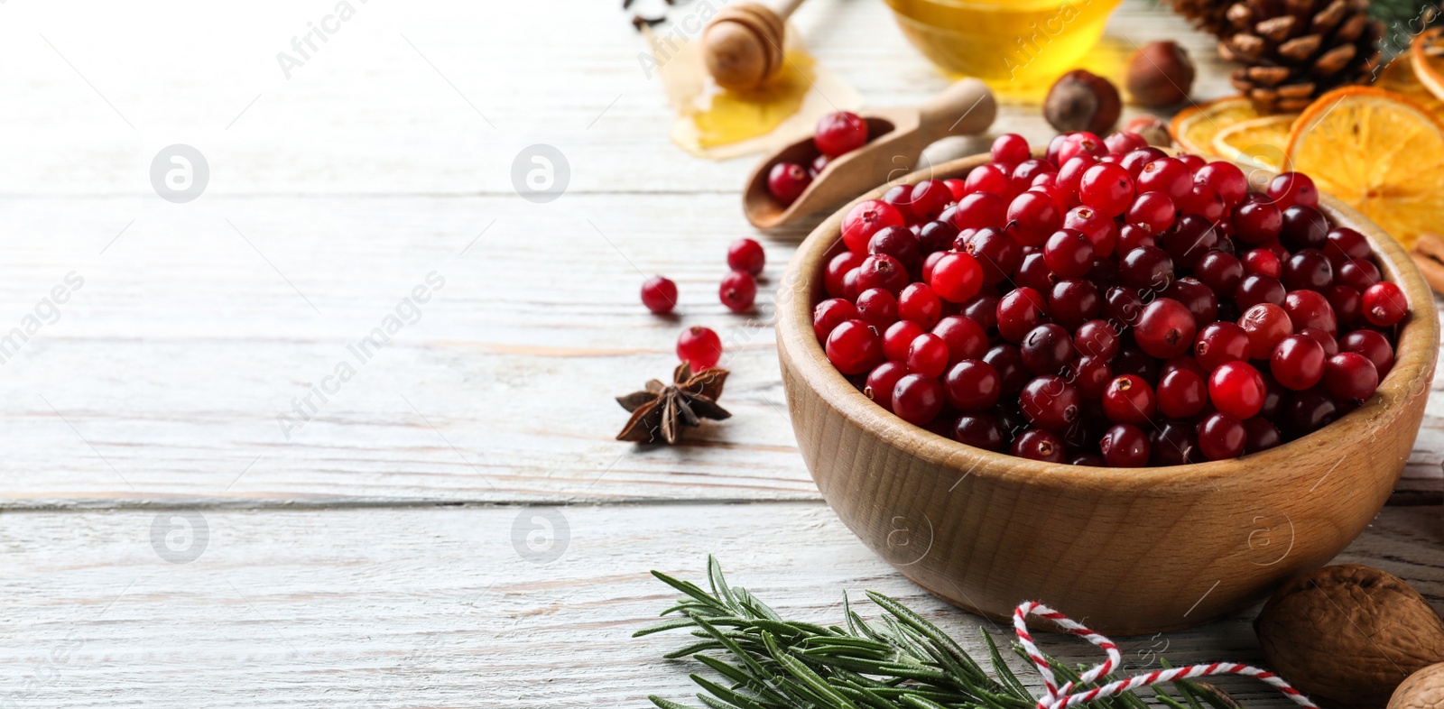 Image of Fresh ripe cranberries, spices and products on white wooden table, space for text. Banner design