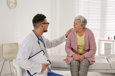 Photo of Doctor examining senior patient in modern office