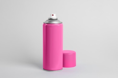 Pink can of spray paint on light grey background